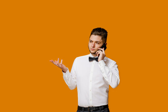 Manager With Phone Calls And Points To Text Of Advert Left Side. How To Make Online Order In Restaurant For Delivery. Isolated Orange Backround. Online Work At Home Quarantine Concept