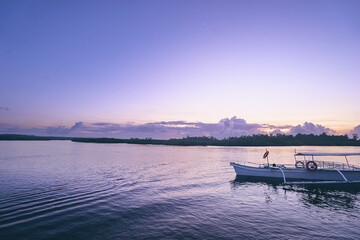 Obraz premium Beautiful colorful sunset on the seashore with fishing boats. Philippines, Siargao Island.