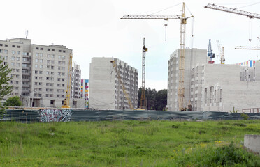 Construction crane and building under construction in the city. Apartments for sale. Housing concept