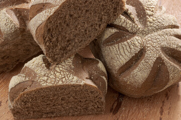 Round Australian bread on wooden base on black background.
