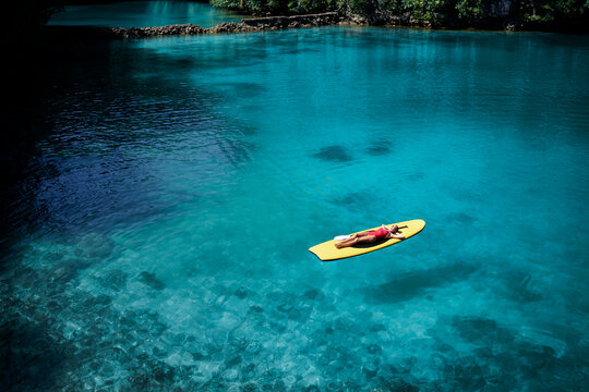 Summer holidays vacation travel. Young woman sailing on paddle board in beautiful calm lagoon.