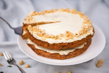 Carrot cake and hazel nuts on the white tablecloth