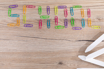 Inscription - school made of colorful office paper clips. School chalk arranged evenly.