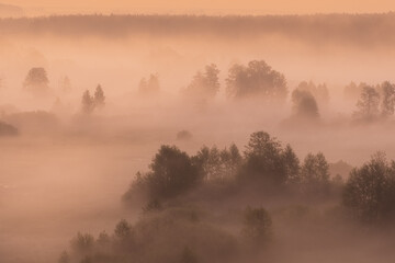 Fototapeta na wymiar Photography of beautiful dramatic sunrise and cloudy misty dark forests and meadows. Aerial view at scenic peaceful early morning countryside nature and horizon line.
