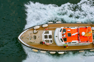 The pilot Boat accompanied by a cruise ship sailing along Orkney islands. Orkney islands, Scotland,...