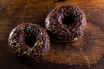 Donuts on a wooden board on a blue concrete background