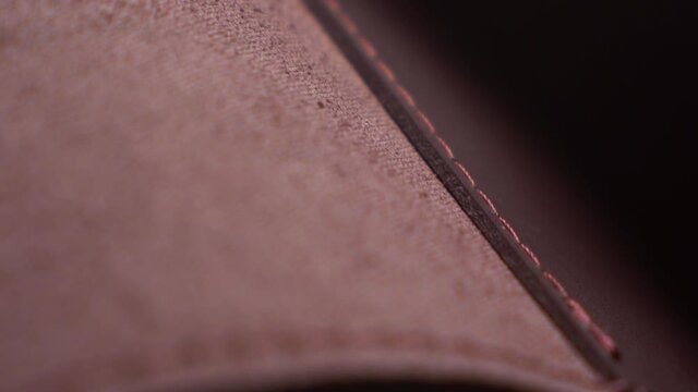 Close Up Woman Fashion Genuine Leather Texture Burgundy Bag Gold Metal Handcrafted Backstich Motion Shots Acsessories Clasp and Belt Details Concept Macro Stich on a Black Background 