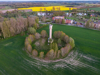 Small countryside city view of fields and old soviet water tower.