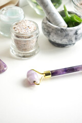 Face rollers, gouache massager scraper, made of natural amethyst. Self-care kit. home Spa products on a white backgroun. Face masks with cucumber and aloe.