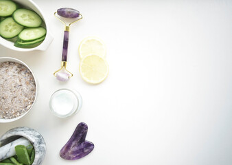 Face rollers, gouache massager scraper, made of natural amethyst. Self-care kit. home Spa products on a white backgroun. Face masks with cucumber and aloe.