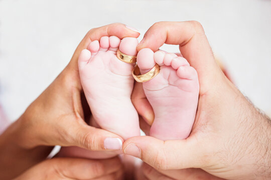 Pies de bebe recien nacido con anillos de pareja reci&eacute;n casada
