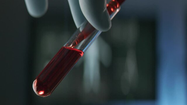 Scientist or a doctor exporting sample blood into a test tube with a pipette in a modern laboratory.	