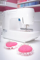 maquina de coser con alfiletero lleno de alfileres. Interior de una sastreria o negocio de arreglos...