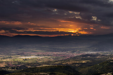 Dark, moody burning sunset cityscape  of Pirot taken from viewpoint on Basara summit on Old mountain