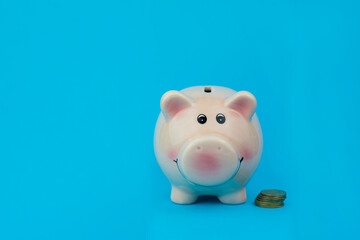 pink piggy file for saving money in a bank with coins on a blue background
