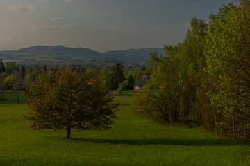 Fototapeta premium Color sunset with fresh meadows and old buidlings near Trojanovice village