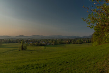 Fototapeta premium Color sunset with fresh meadows and old buidlings near Trojanovice village