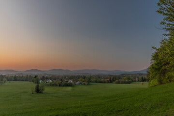 Fototapeta na wymiar Color sunset with fresh meadows and Javornik hill near Trojanovice village