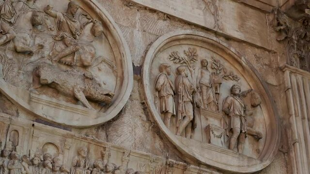Close up of antique stone mosaic with detailed humaniod scultures at a historical building from the ancient roman empire in Rome, Italy.