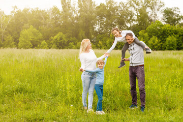 Naklejka na ściany i meble Happy family enjoying life together at meadow outdoor.