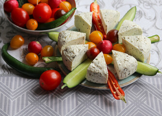 still life with sliced fresh cheese and vegetables