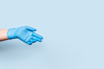 Photo on the spread of diseases in the world. The hand in the blue medical glove is sadly lowered down.
