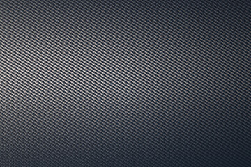 Close up of grey diagonal oriented woven carbon fibre sheet surface.