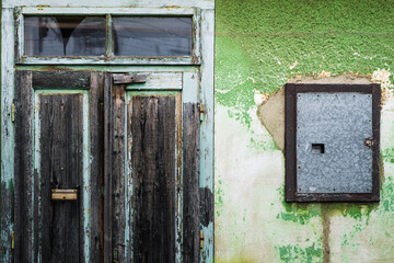 Grunge old vintage doors and damaged green painted wall