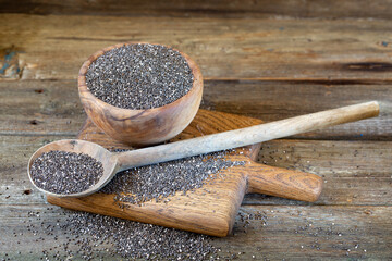 Chia seeds in wooden bowl on wooden background 