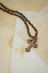 Religion concept. Christian religion. Wooden cross on a wooden chain. The cross is made of light...