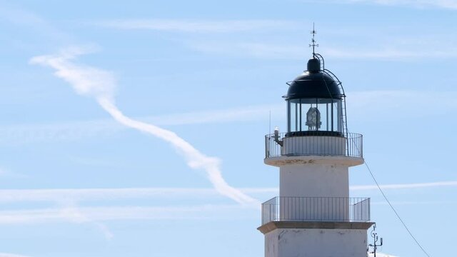 Cap de Creus lighthouse with rotating Fresnel lens on a blue sky background
