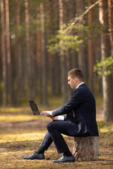 Fototapeta premium freelancer with laptop working in forest