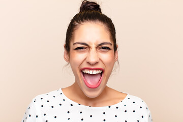 young latin woman looking happy and friendly, smiling and winking an eye at you with a positive...