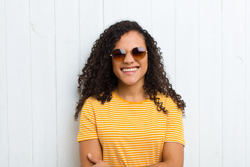 young latin woman looking happy and friendly, smiling and winking an eye at you with a positive...