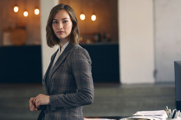 Beautiful portrait of very attractive female CEO business woman wearing a suit standing in her office looking confidently in camera.  - obrazy, fototapety, plakaty