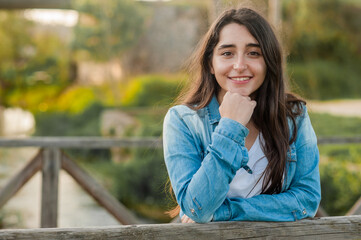 Obraz premium caucasian girl standing on a wooden bridge looking at the camera. great copy space