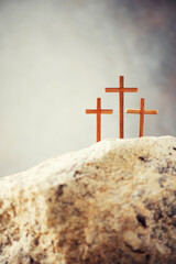 Three wooden cross on Calvary hill, grey background. Crucifixion, resurrection of Jesus Christ. Christian Easter holiday, Golgotha. He risen and alive. Jesus is the reason. Gospel, salvation concept