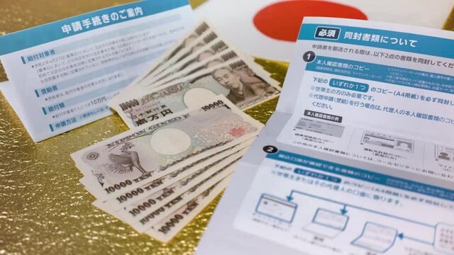 Close-up slide video of bank notes and documents for application procedure of special fixed 100000 yen benefit sent by the Japanese govt of Abe Shinzo to fight the unemployment caused by COVID-19.