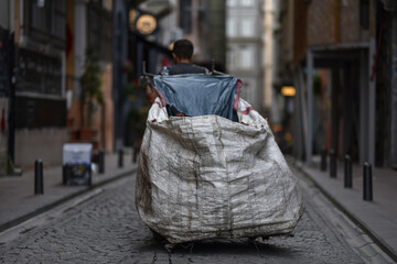 Poor garbage man pulls a trash cart along the street of Istanbul