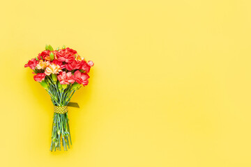 Red carnation flowers bouquet on yellow background. Mother's day, Valentines Day, Birthday celebration concept. Copy space, top view