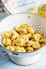 Tortellini pasta. Italian stuffed pasta in colander.