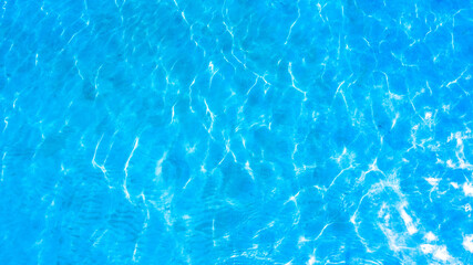 Blue background, texture of water surface with sunlight reflections