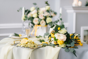 Beautiful wedding decor and table setting made of fresh flowers, a bride's bouquet of white and pink roses, lemons, side view