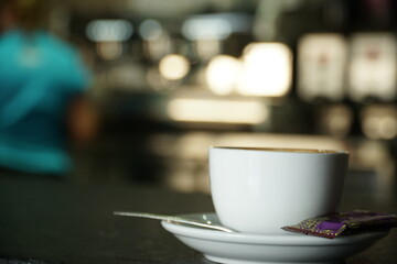 Taza de café con leche por la mañana para desayunar. Viene con galleta