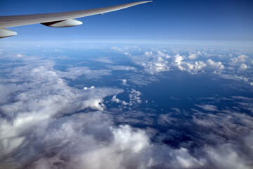 Fototapeta na wymiar under the wing of an airplane blue sky