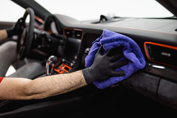 A man cleaning car interior, car detailing (or valeting) concept. Selective focus.