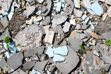 Construction waste, broken concrete panels, tiles on ground in sunny day, top view