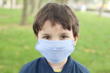 niño en el campo con mascarilla por el coronavirus