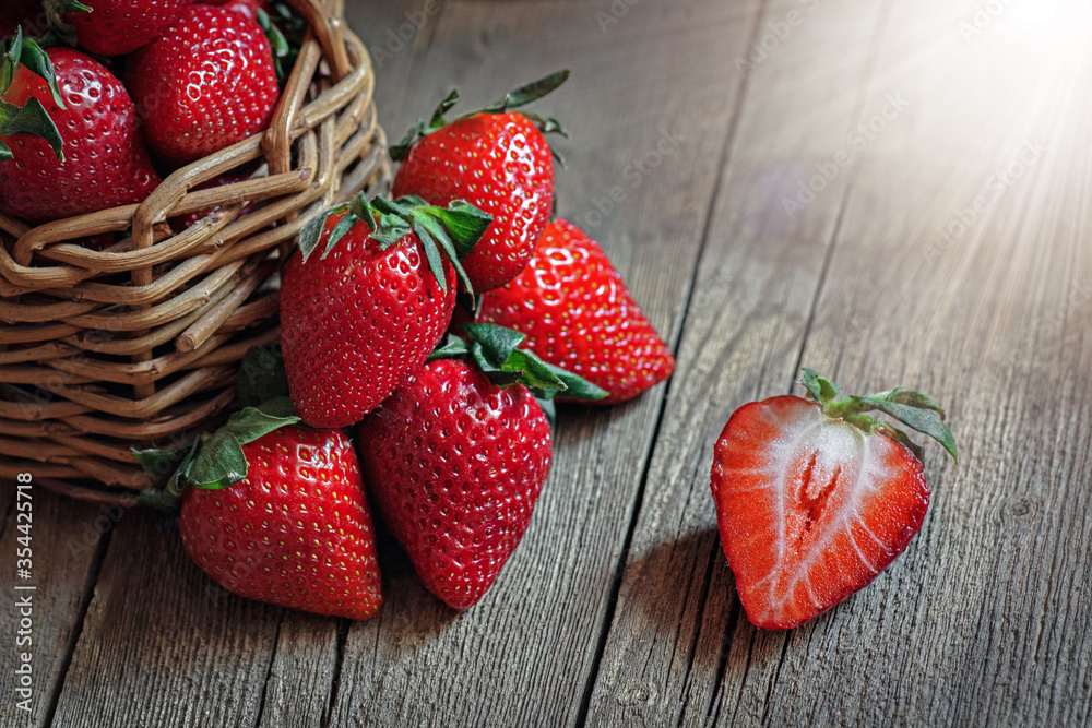 Wall mural strawberry still life on wooden background, a pile of strawberries in a basket and on the table