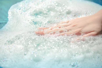 Foto op Plexiglas hand in foam, airy soapy foam on the water, take a bath with foam, wash clothes © Leka